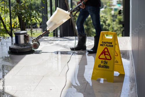 The people cleaning floor with machine.