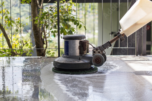 The people cleaning floor with machine.