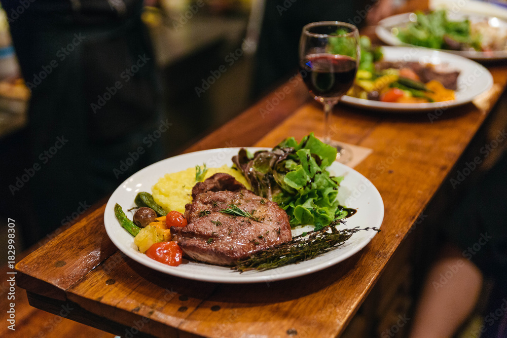 Stir fried pork steak served with vegetable side dish, salad and mash potato topping with balsamic dressing and red wine. Stir fried pork steak served with vegetable side dish, salad and mash potato topping with balsamic dressing and red wine.