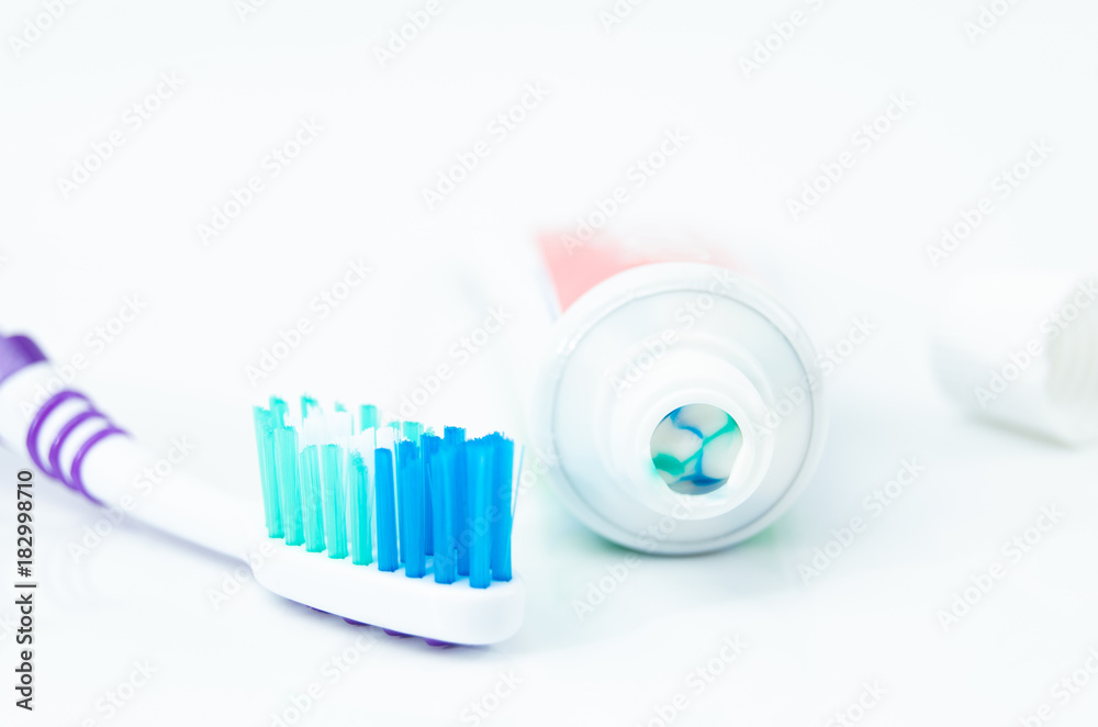 A tube of toothpaste and a toothbrush on white background A tube of toothpaste and a toothbrush on white background