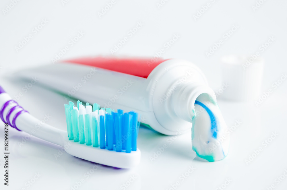 A tube of toothpaste and a toothbrush on white background A tube of toothpaste and a toothbrush on white background