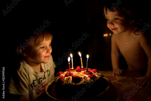 children are looking at a cake