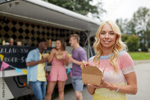 happy woman with wok and friends at food truck