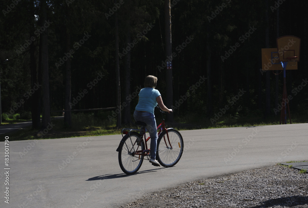 Side view portrait of a young beautiful woman riding on bicycle in city street