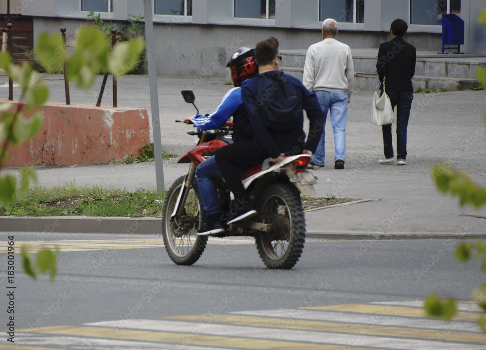 a motorcyclist with a passenger without a helmet