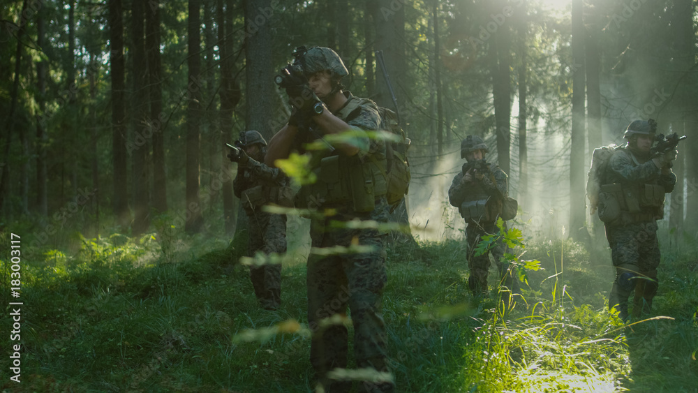 Five Fully Armed Soldiers Stand Alert with Guns Ready. Military Operations Takes Place in the Sunny Dense Forest.