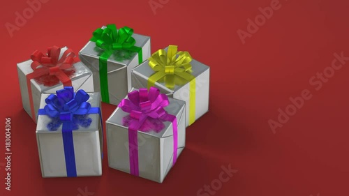Gift boxes with colorful ribbons rotating in perfect loop on red background