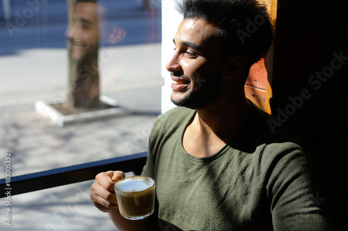 Arabian businessman waiting for partner and drinking coffee in s photo