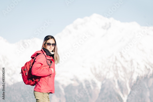 Backpacker girl on background of winter mountains.