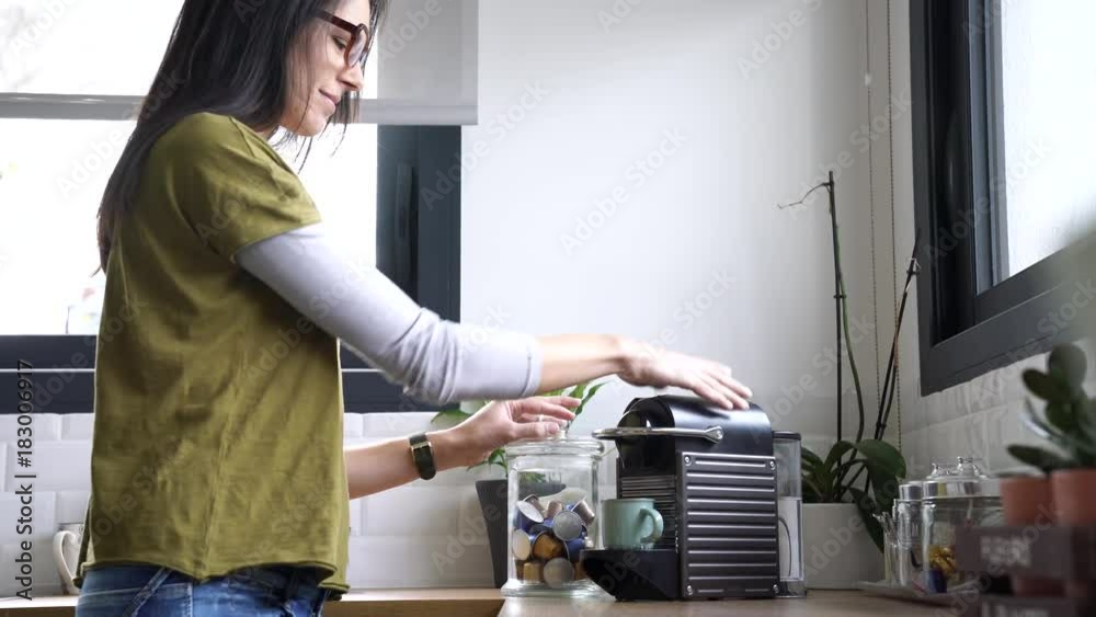 Brunette girl making expresso from coffee machine