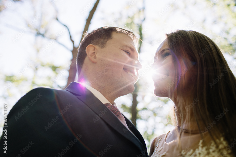 Young bride and groom walking high in mountains. Amazing weather with fog and sun Young bride and groom walking high in mountains. Amazing weather with fog and sun
