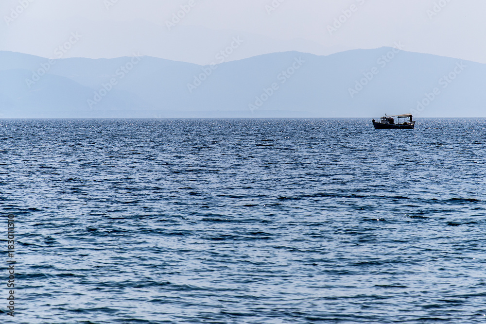 Naklejka premium boat on the sea in the distance 