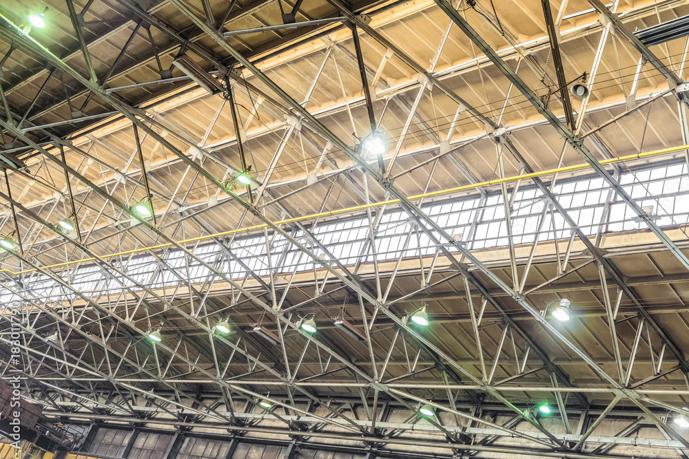 Metal trusses covering an industrial long-span building with an antiaircraft lantern of natural light