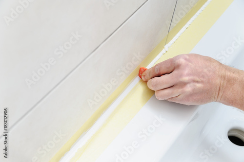 A man is smoothing the silicone sealant. photo