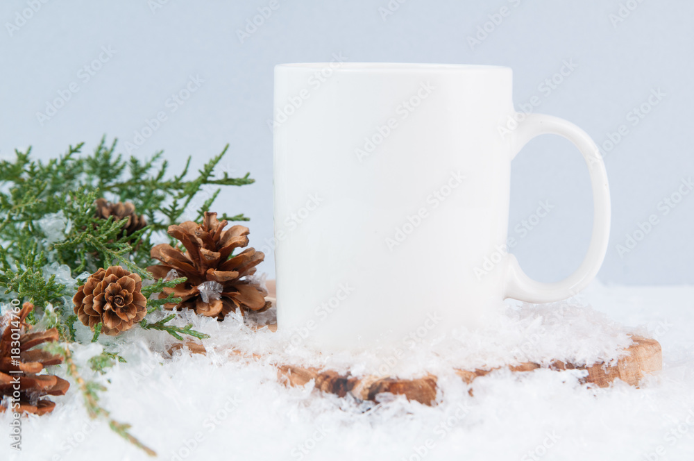 white mug in snow with festive greenery white mug in snow with festive greenery