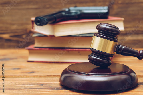 Obraz na płótnie Judge gavel, law books and gun  on a wooden background