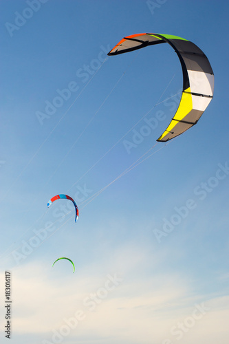 Kitesurfing kites on a clear blue sky. Summer activities.
