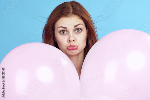 woman with two balloons, emotions, light background, close-up