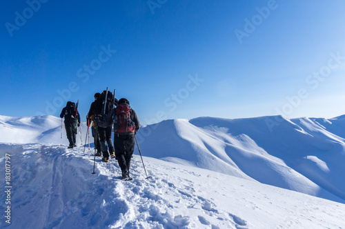 People hiking in the snow at Vardousia mountain in Central Greece- E4 path