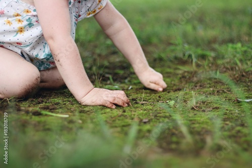 Child playing in the dirt and grass