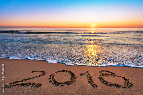 New Year 2018 is coming concept. 2018 written on sandy beach