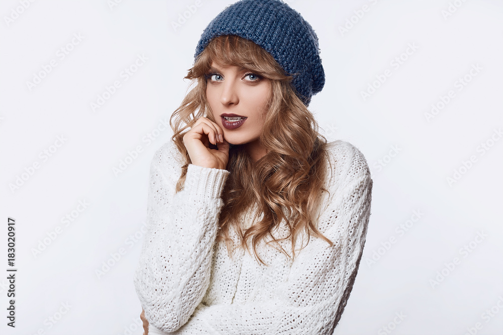 Positive blond woman in sweater and hat isolated on white background Positive blond woman in sweater and hat isolated on white background