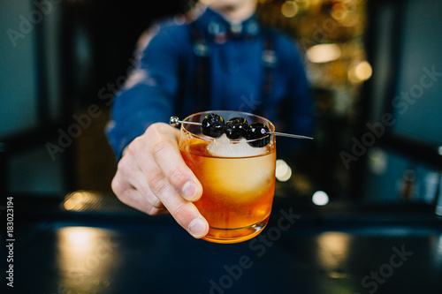Fotografie Bartender is making cocktail at bar.