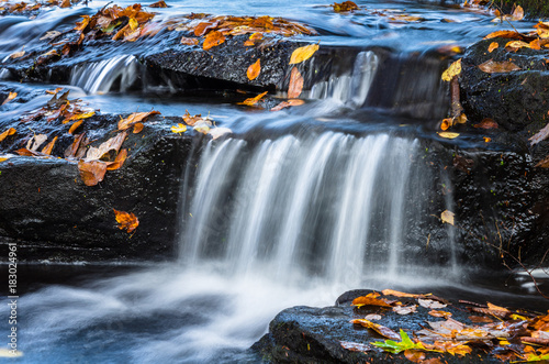 Close View of Small Waterfall in Autumn with Fallen Leaves on the Wet Rocks. Southford Falls Provincial Park  CT.