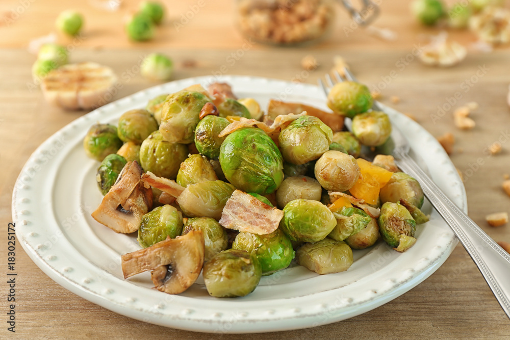 Plate with yummy brussel sprouts salad on wooden table Plate with yummy brussel sprouts salad on wooden table