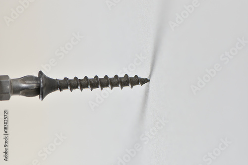 Installing a black spiral threaded sheetrock or drywall screw