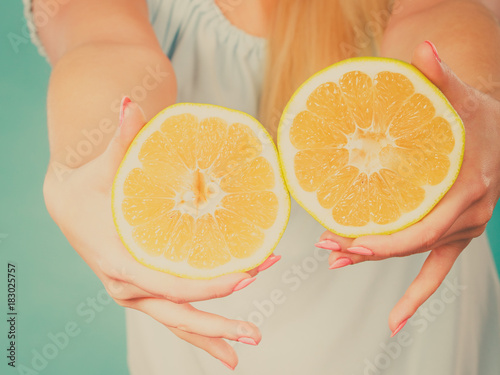 Halfs of yellow grapefruit citrus fruit in human hands