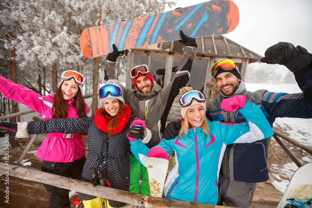 Obraz premium Group of happy friends on cold winter day at mountain cottage and having fun