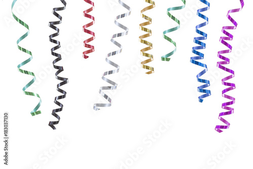 horizontal festive image with close-up multi coloured rolls curly ribons hanging from the top on black backgroung photo