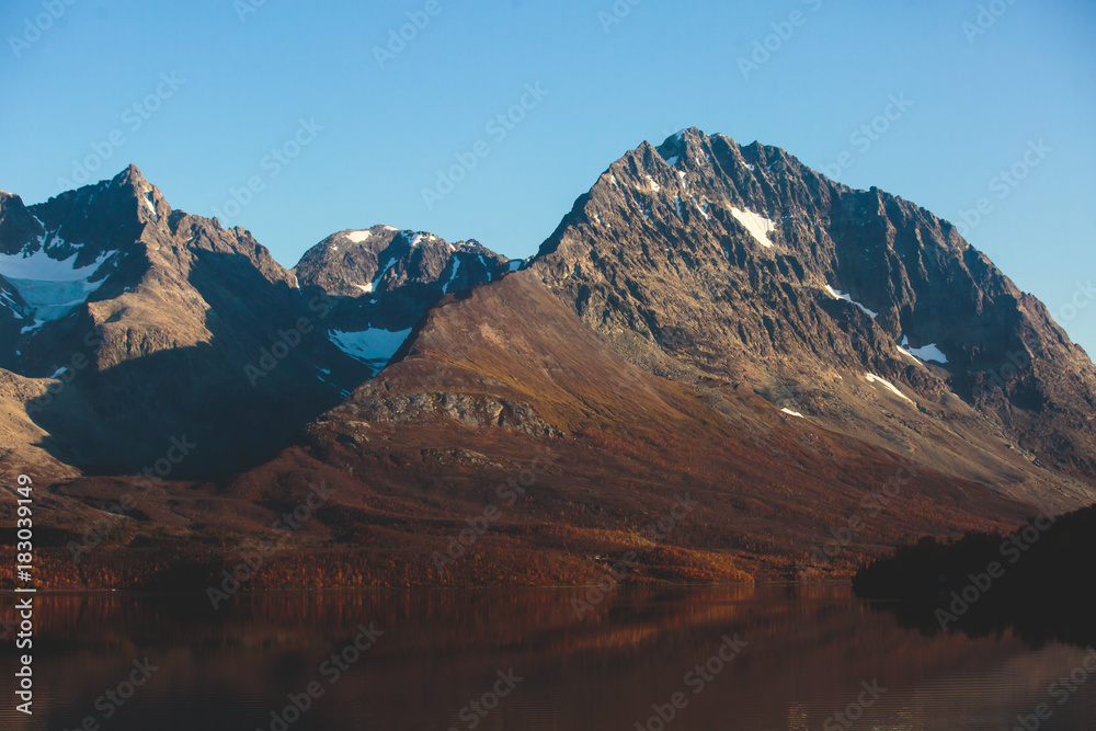 Beautiful vibrant summer view of Norwegian mountains and fjord reflection, Lyngen Alps, Finnmark county, northern Norway