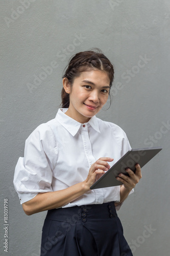 Beautiful asian business woman smiling while using tablet photo