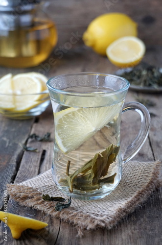 Hot green tea with lemon in a glass cup