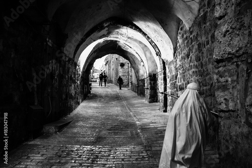 BAITULMUQADDIS, PALESTINE - 11TH NOV 2017; Pilgrimage walking down the alley in Jerusalem old city,  a place of pilgrimage and worship for Muslims, Christians and Jews since the biblical era. 