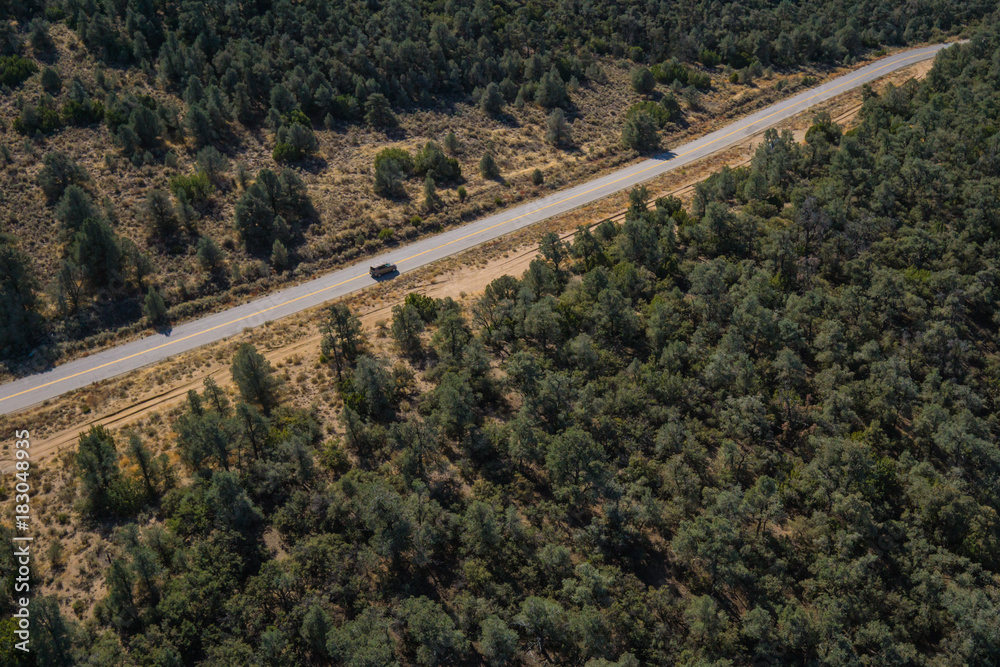 View of single road through evergreen forest viewed from high above.