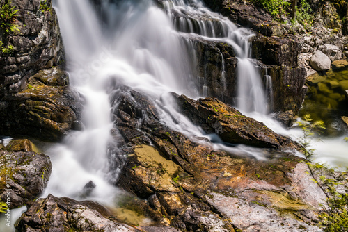 beautiful cascading waterfall under the sun with long exposure.