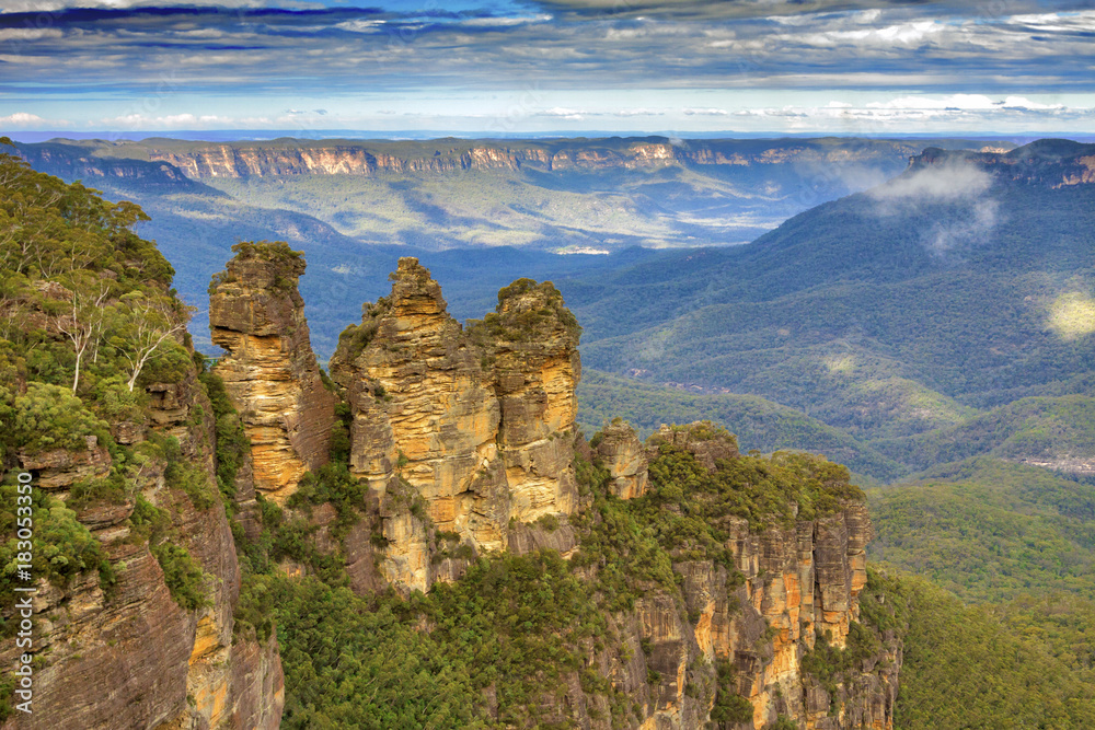 Fototapeta premium Australia - New South Wales - Unusual Three Sisters rock formation with surrounding impressive landscape of Blue Mountains National park