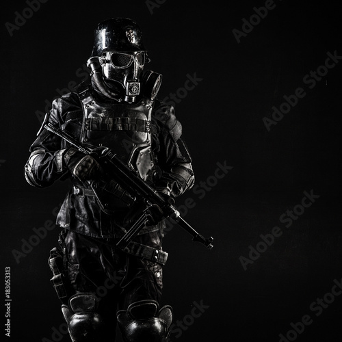 Futuristic nazi soldier gas mask and steel helmet with schmeisser handgun black background studio shot