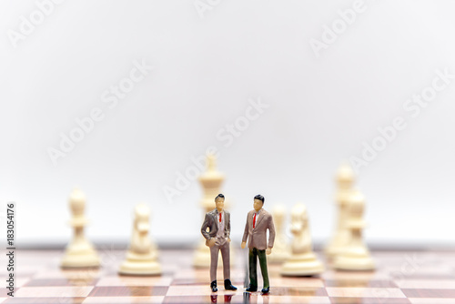 Miniature businessman and partner lawyers or politicians on a chessboard. Business Concept