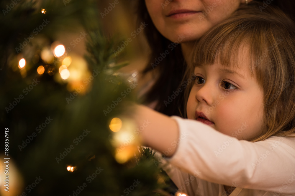 Little girl busy in decorating christmas tree Little girl busy in decorating christmas tree