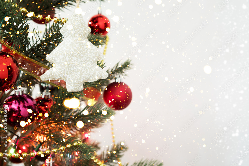 Close-up of Christmas tree with ornament, decoration and light bokeh with snowfall on winter background