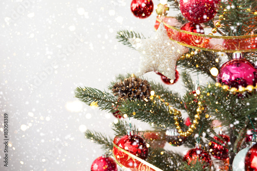 Close-up of Christmas tree with ornament, decoration and light bokeh with snowfall on winter background