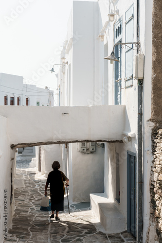 Old lady in black with stick and shopping walking home, Kastro Village, Sifnos, Cyclades, Greek Islands, Greece photo