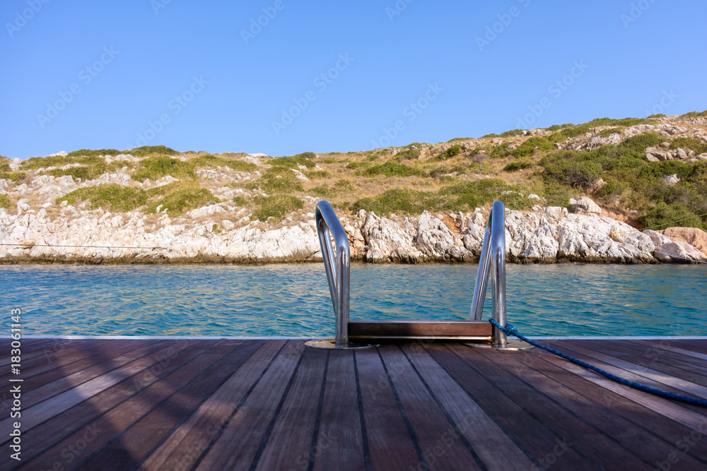 The rear deck of a sailing yacht, over the gorgeous waters of Arki island, Dodecanese, Greece