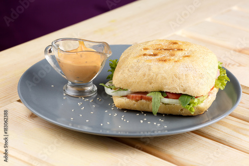 Panini with sause in the grey plate on the wooden table