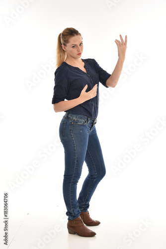  full length portrait of air wearing blue shirt and denim pants, standing pose on white background.