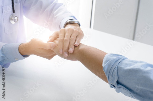 Doctor holding patient s hand  and reassuring his male patient helping hand concept.